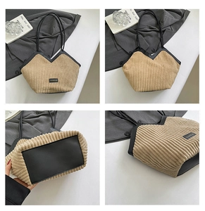 Detail view of khaki corduroy tote bag with black leather base and stitching accents