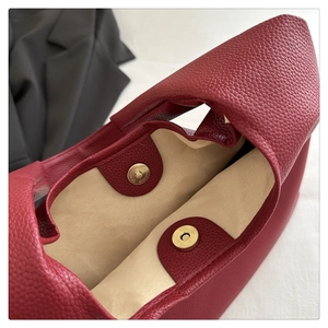 Dettaglio interno della borsa in pelle rosso scuro con chiusura a scatto magnetico dorato