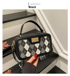 Detail view of contrast argyle pattern handbag with wide geometric shoulder strap