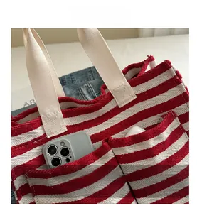 Detailansicht der rot-weiß gestreiften Canvas-Tasche mit zwei Vordertaschen und Webgriffen