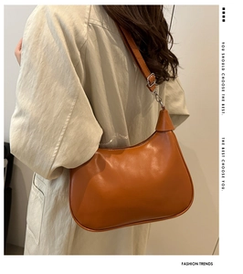 Close-up of caramel leather hobo bag with adjustable silver metal buckle detail