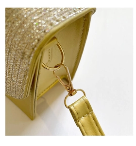 Detail of light gold sequins and quilted synthetic leather strap with metal hook
