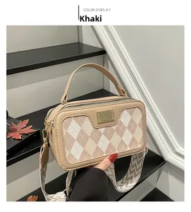 Detail view of khaki crossbody bag featuring quilted patterns and dual zippers