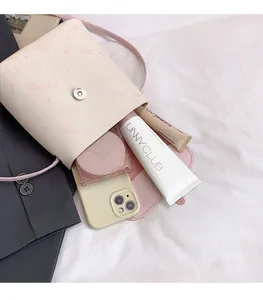 Detail of pink cartoon bucket bag interior showing space for phone and cosmetics