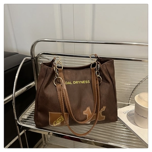 Détail du sac cabas en toile avec lanières en cuir marron et imprimé 'DAL DRYNESS'