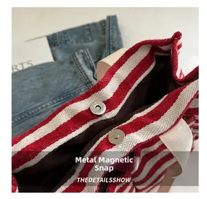 Detailaufnahme des Metall-Magnetverschlusses und des gestreiften Stoffes der Tasche