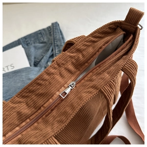Detail of brown corduroy tote bag featuring a durable zipper closure and soft inner lining