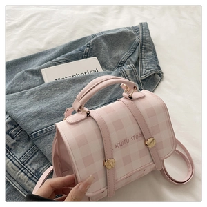 Close-up of pink checkered pattern backpack with gold metal clasp and logo detail