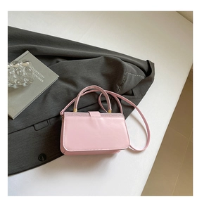 Détail du sac à main rose avec bordure pailletée sur fond de tissu gris élégant