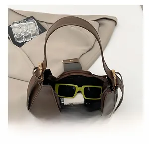 Top view of brown crescent handbag interior showing storage space with sunglasses