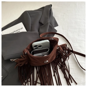 Détail du sac bandoulière vintage en daim marron avec franges, rangement et fermoir magnétique