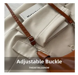 Detail of adjustable silver buckle on brown oil wax leather shoulder bag with lychee texture