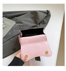 Détail des fermoirs magnétiques et de la doublure noire du sac à bandoulière rose