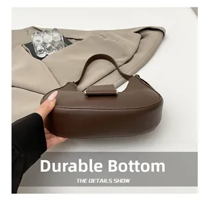 Close-up of a minimalist crescent shoulder bag featuring a durable wear-resistant bottom