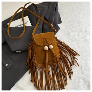 Détail du sac bandoulière vintage en daim marron avec de longues franges et perles
