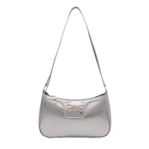 Sac baguette argenté avec nœud doré et longue bandoulière de style moderne