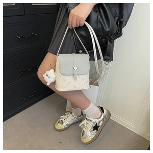 Detail of contrast flap crossbody bag with cartoon cat print and silver heart buckle