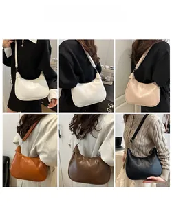 Detailed view of crescent moon shoulder bags in multiple colors shown on a model
