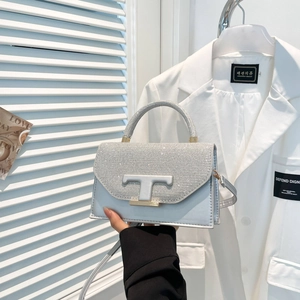 Sac à main en cuir gris argenté avec rabat scintillant et fermoir métallique en forme de T