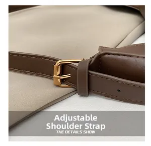 Close-up of adjustable brown leather shoulder strap with gold metal buckle and neat stitching