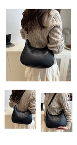 Detail view of black crescent crescent bag with adjustable strap and silver metal buckle