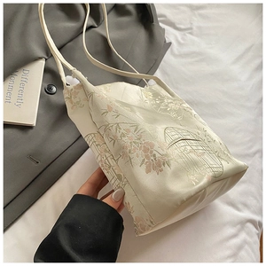 Détail du tissu jacquard floral avec motifs brodés de fleurs et de cages à oiseaux