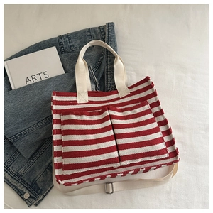 Detail der rot-weiß gestreiften Canvas-Einkaufstasche mit Vordertaschen auf Denim