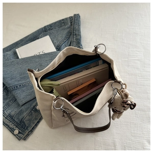 Top view of a spacious canvas tote bag with brown leather straps and interior items