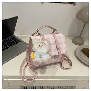 Detail of pink plaid PU leather bag with cute plush bear charm and adjustable strap