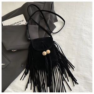 Détail d'un sac à bandoulière noir givré avec franges bohèmes et perles de bois naturel
