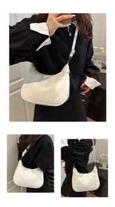 Detailed view of white minimalist half-moon bag with adjustable strap and silver buckle