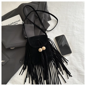 Détail du sac bandoulière en daim noir avec de longues franges et perles en bois décoratives