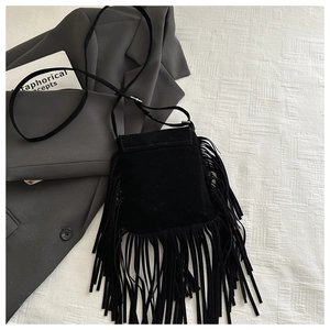 Détail du sac bandoulière en daim noir avec de longues franges et une sangle réglable