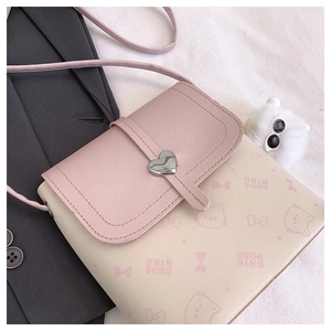 Detail of pink cartoon cat pattern and silver heart buckle on crossbody bag strap