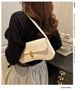 Détail du sac sous le bras crème gaufré crocodile avec élégant fermoir rotatif doré ovale