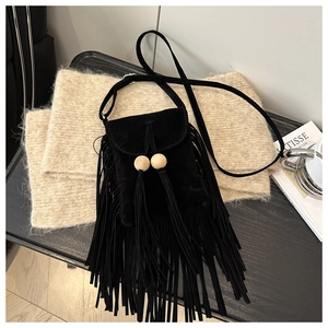 Détails d'un sac bandoulière vintage noir avec pompons à franges et perles en bois
