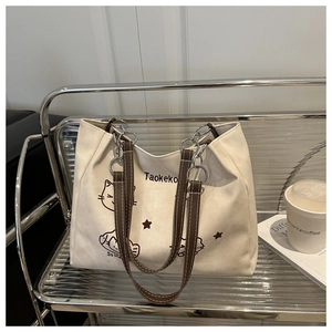 Detail of white canvas tote bag with brown leather straps and artistic cat print