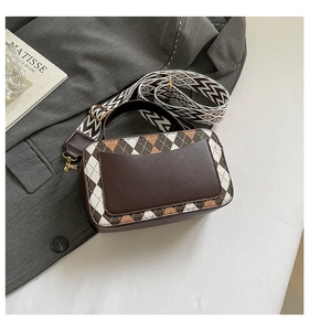 Detail of a brown quilted crossbody bag with stylish geometric jacquard wide shoulder strap