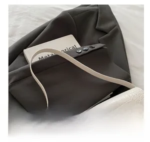 Détail du sac baguette blanc à motif crocodile avec fermoir rotatif doré élégant