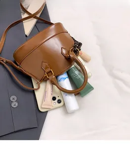 Top-down view of brown shell bag interior showing storage space for phone and makeup
