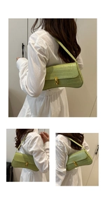 Détail du sac à main vert clair gaufré crocodile avec un fermoir ovale en métal doré