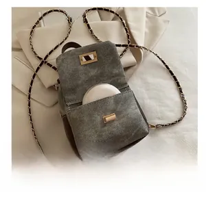 Detail of vintage canvas mini backpack showing storage pocket and gold chain strap
