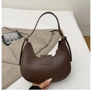 Detail of dark brown hobo bag showing high-quality matte leather texture and gold buckle