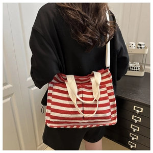 Detail der rot-weiß gestreiften Canvas-Tasche mit Vordertaschen an einem weiblichen Model