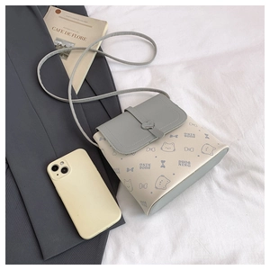 Detail of cute beige PU leather crossbody bag featuring cartoon cat prints and heart buckle