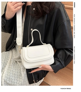 Détail du sac bandoulière blanc avec sangle large et finitions dorées