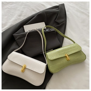 Detail of elegant crocodile-textured leather bags with golden T-shaped metal twist locks