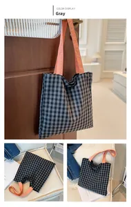Detail view of grey plaid tote bag with pink straps shown against a home interior backdrop