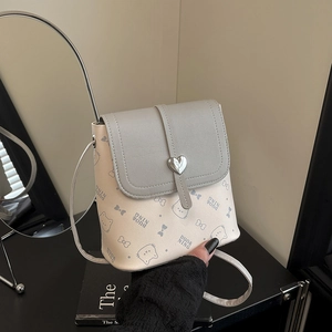 Mini crossbody bucket bag with cat prints and heart metal clasp shown in hand