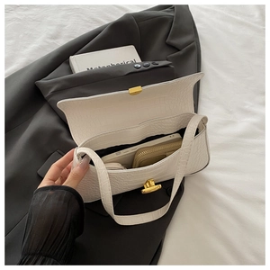 White croc-embossed underarm bag detail showing interior space for phone and wallet